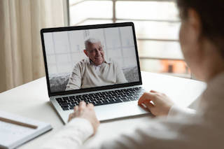 Giovane che effettua una videochiamata con il padre anziano
